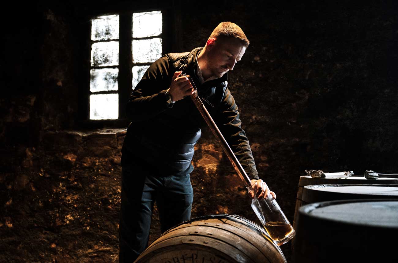 A man drawing whisky from a barrel