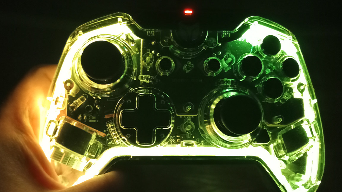 A hand holds the BigBig Won Rainbow controller