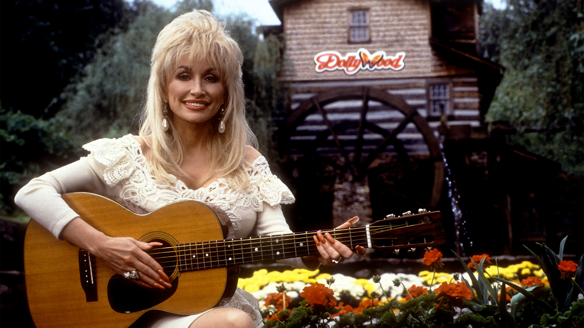 Dolly Parton poses for a portrait with her guitar at Dollywood circa 1993 in Pigeon Forge, Tennessee.