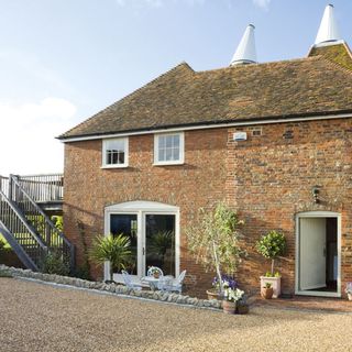sloping roof house with exposed brick wall and white door