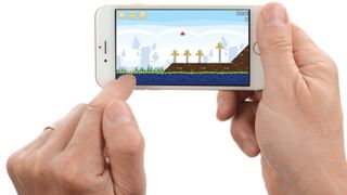 Hands playing Angry Birds on iPhone