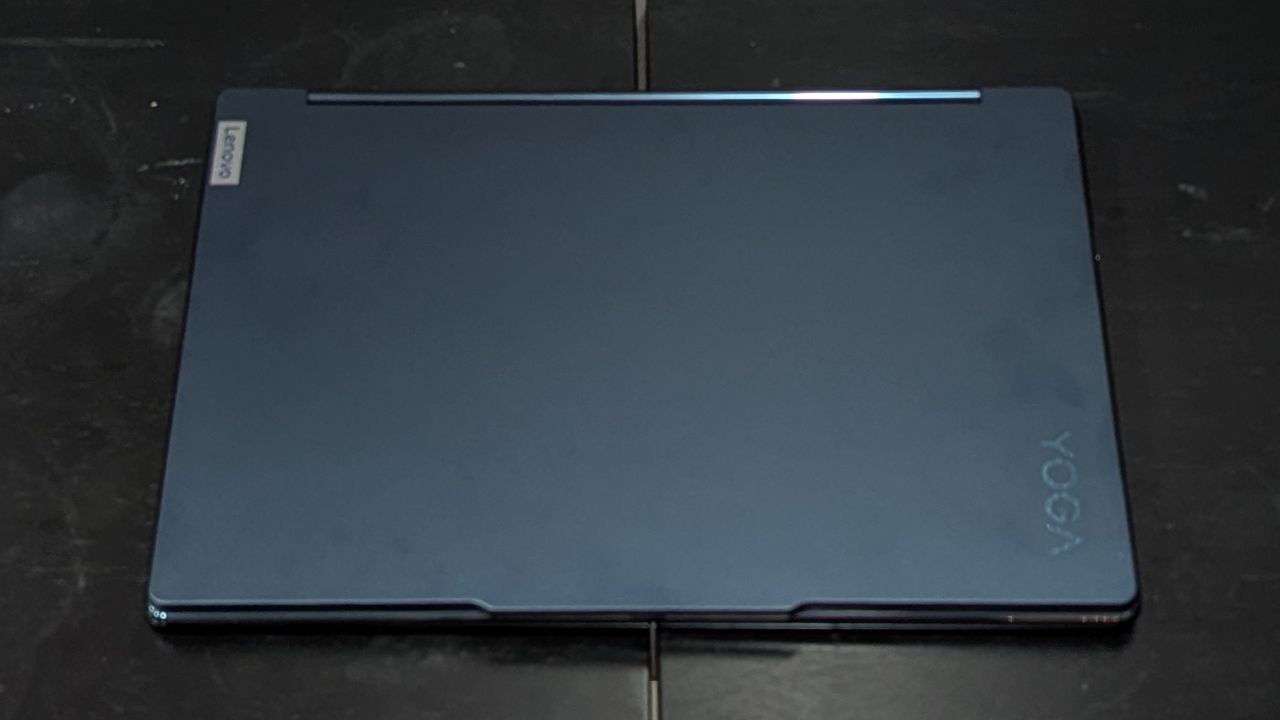 A top-down view of closed laptop on top of a black surface