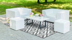 Garden seating and coffee table grouped around outdoor rug