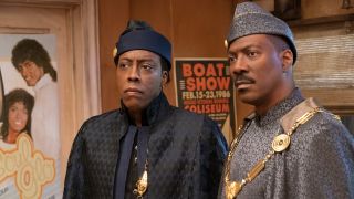 Arsenio Hall and Eddie Murphy standing in the barbershop in Coming 2 America.