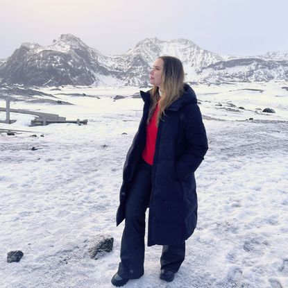 valeza wearing cold weather clothing from the article in front of a snowy mountain scene