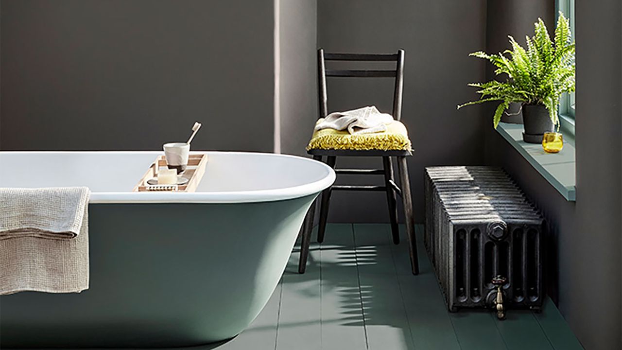 Black bathroom with little greene paint and green bath