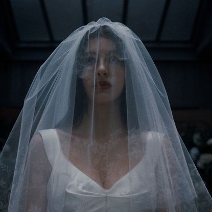 camila morrone in something very bad is going to happen wearing a white veil and wedding dress walking down the aisle in the finale