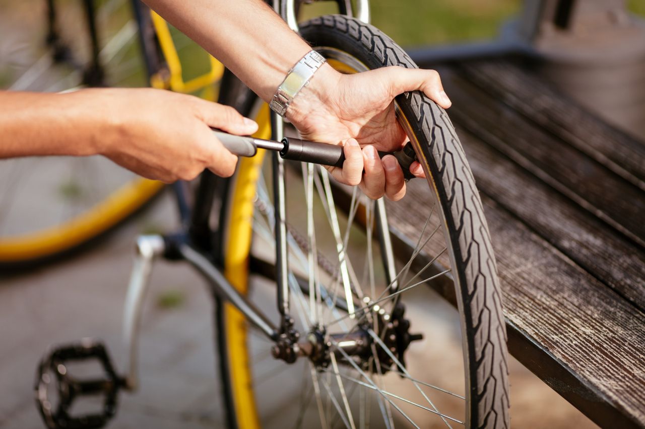 How to fix a puncture and mend an inner tube image shows someone pumping up a rear tyre with a mini pump