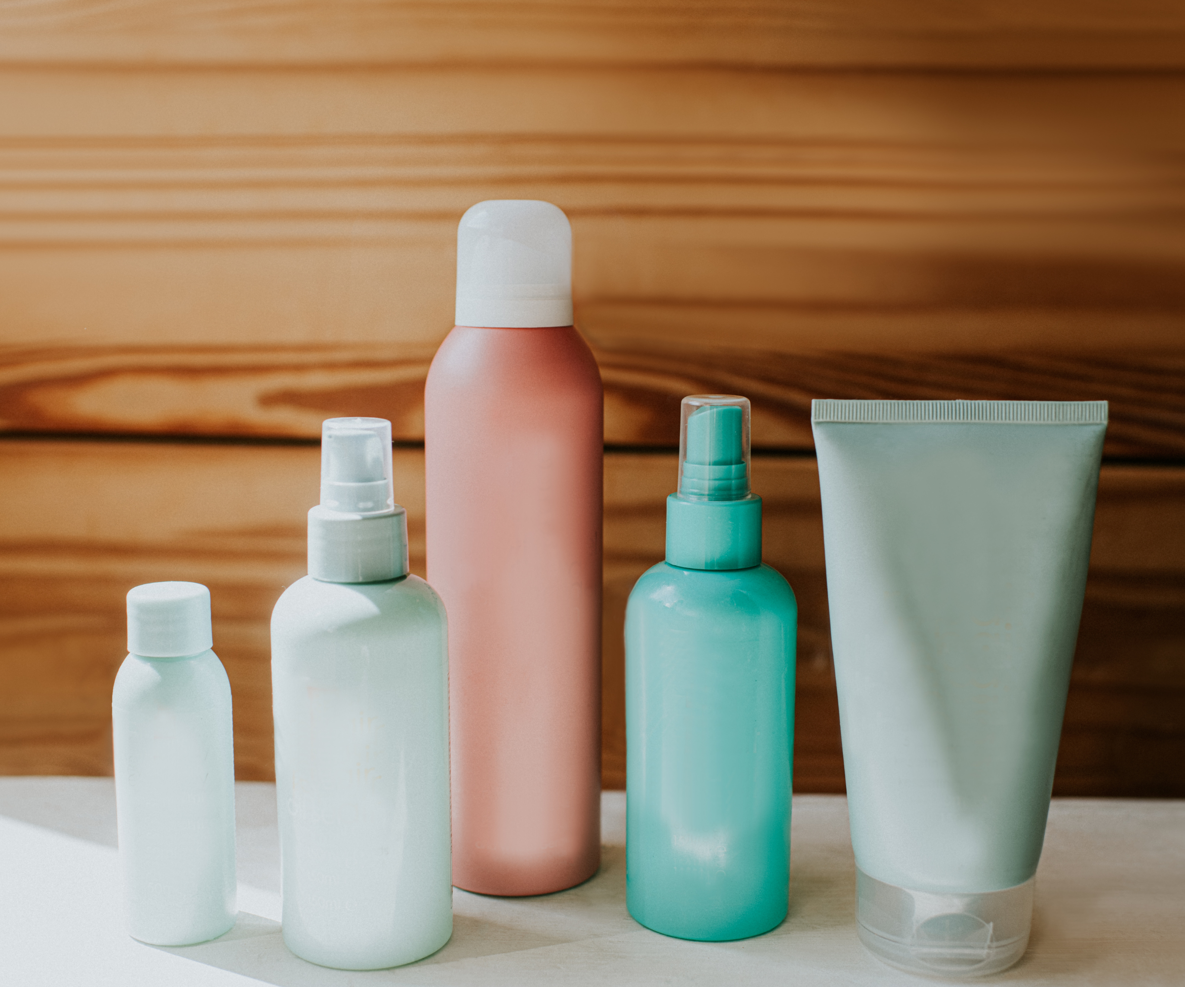 TOILETRIES LINED UP IN FRONT OF WOODEN SUFRACE
