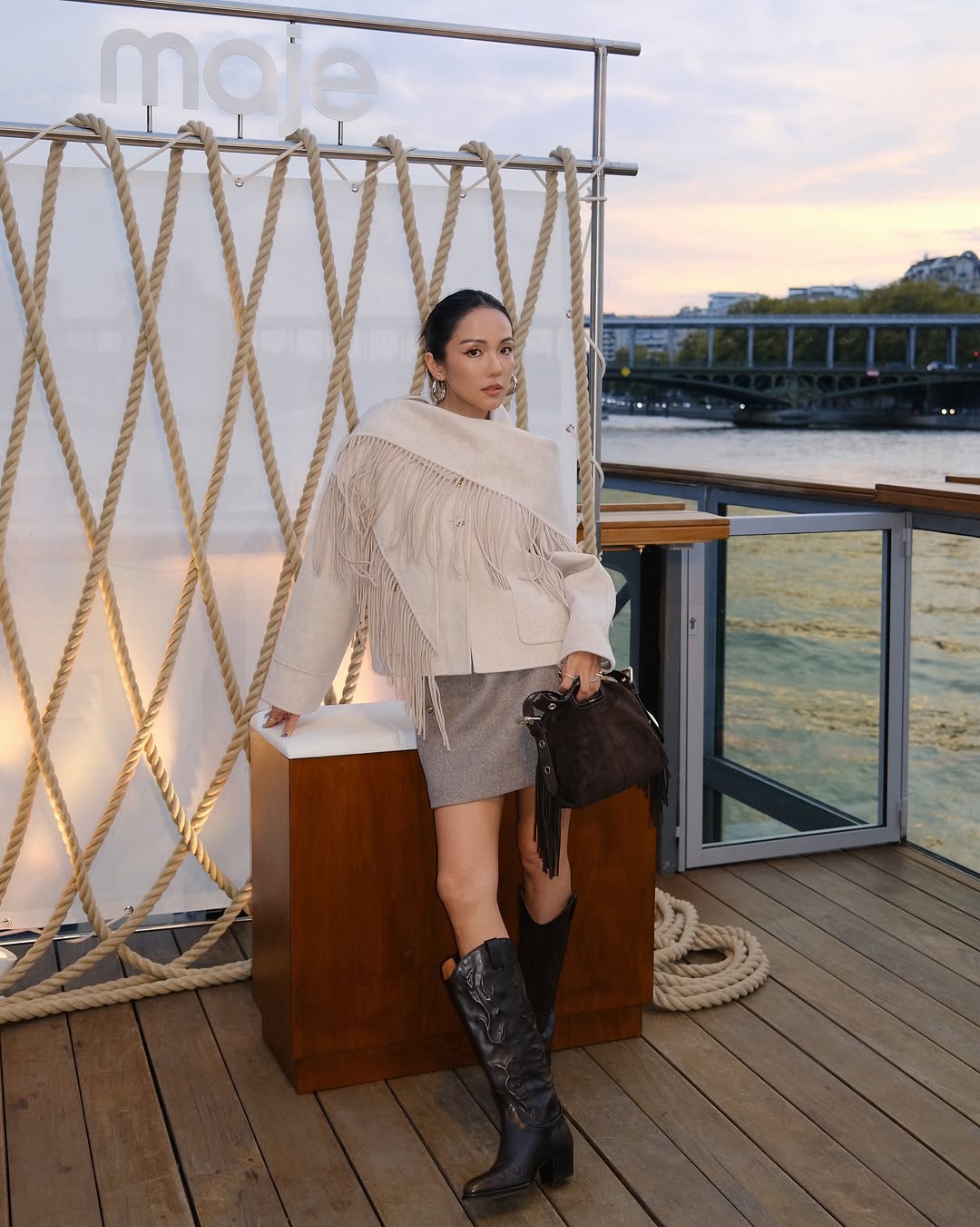 Woman wearing fall boots with skirt outfit 2025.