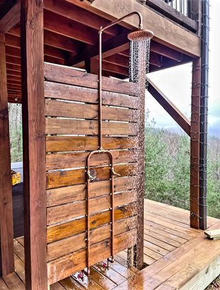 copper outdoor shower on a wooden platform