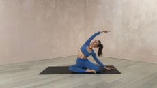 woman on yoga pat does Pilates strecth