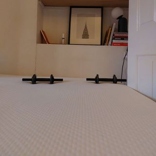 Two 1kg weights resting on the surface of the REM-fit eco hybrid mattress