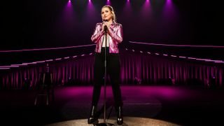 Press imagery for Netflix's Taylor Tomlinson: Have It All, with the comedian on a purple stage.