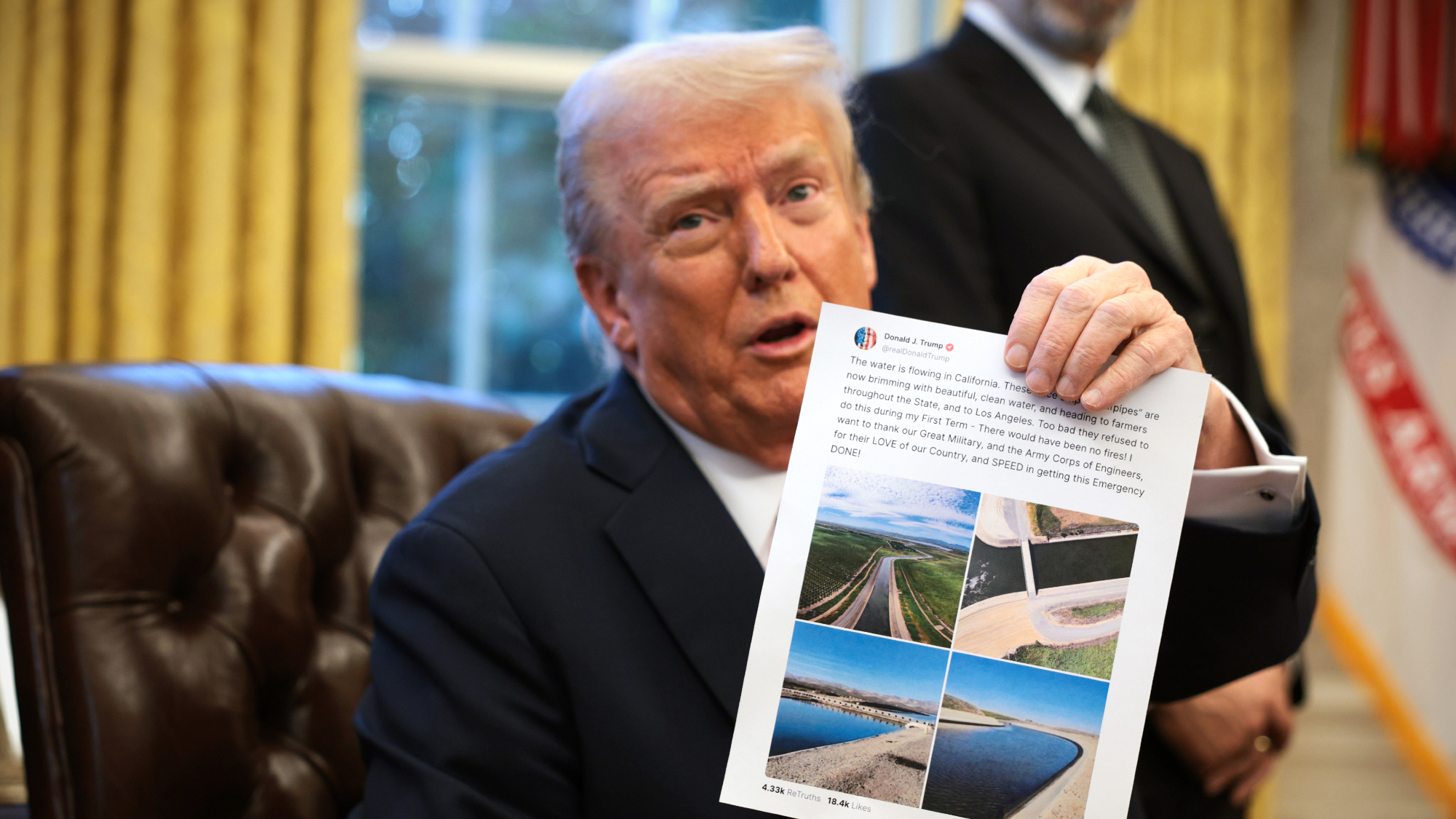 President Donald Trump holds up a printout of one of his Truth Social posts