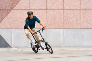Person riding a folding Brompton bike