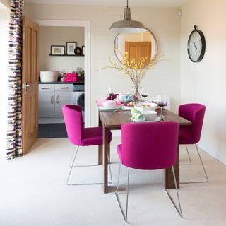 Neutral dining room with bright purple pink chairs