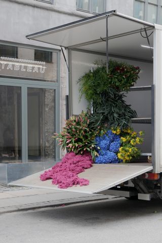 Installation comprising pink reindeer moss, pink lilies, blue hortensias, yellow fritillaries, eucalyptus, asparagus ,burgundy peonies,