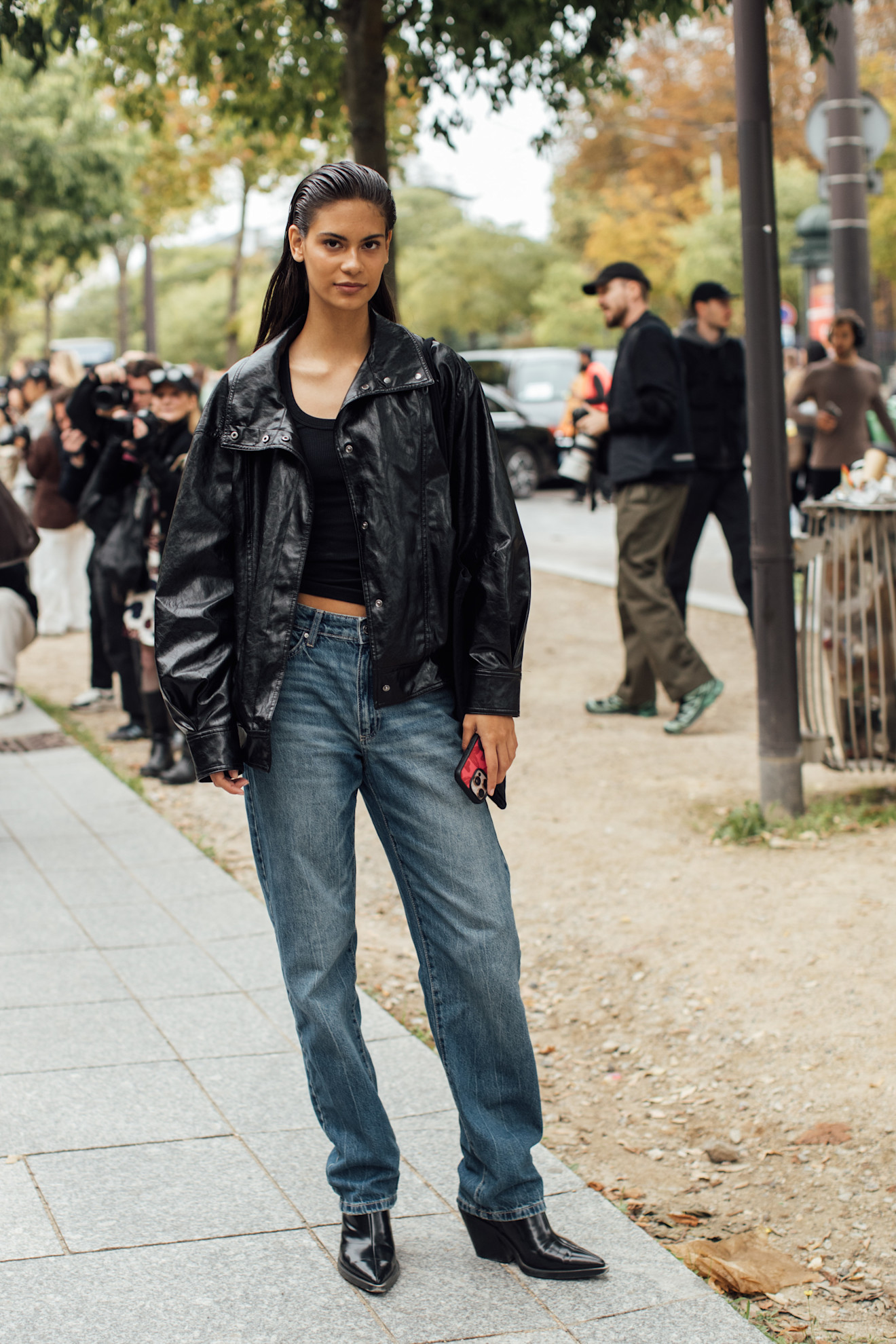 Woman in wedge boots, baggy jeans, black, and a funnel-neck jacket.