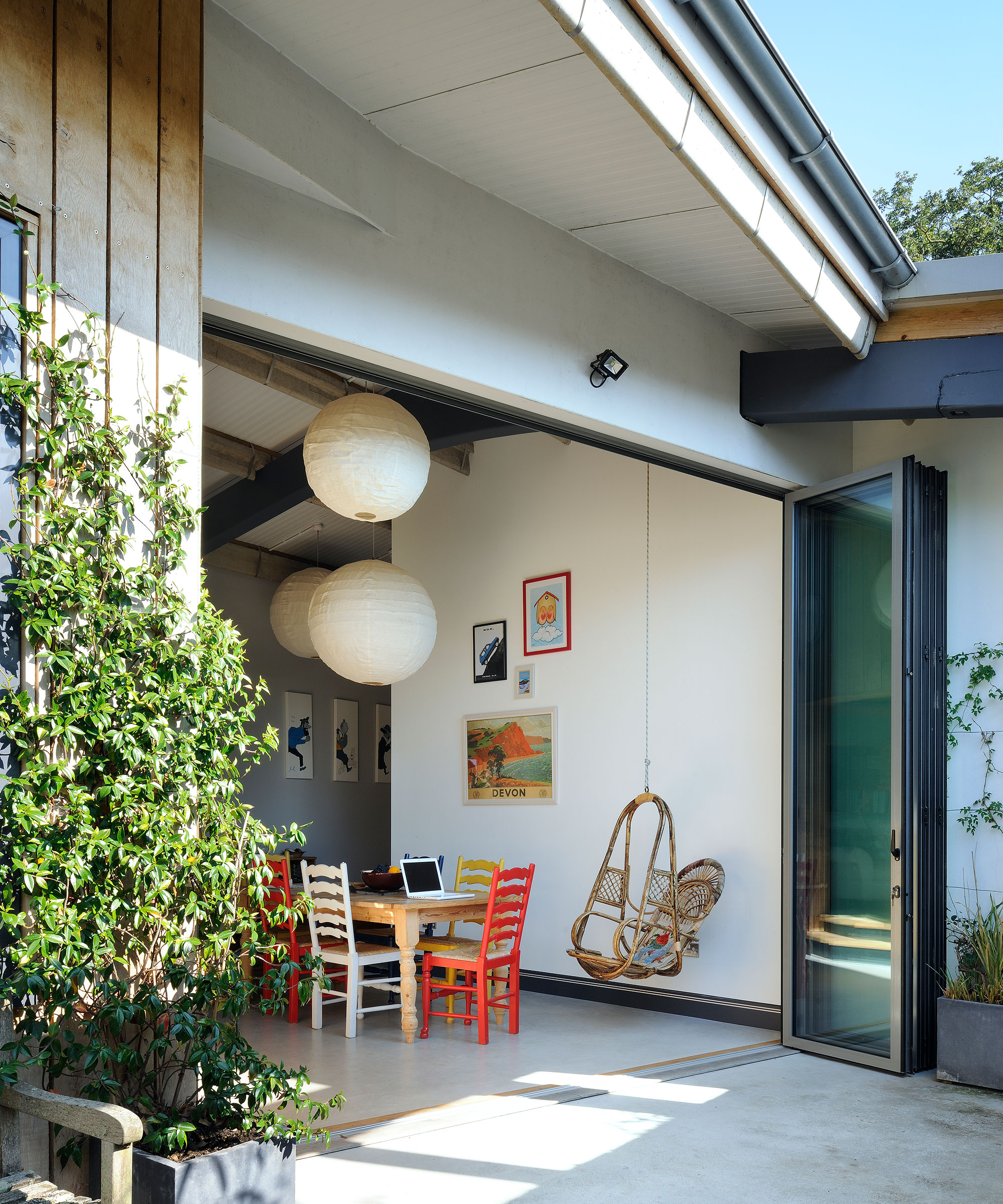 black aluminium bifold doors leading from children's play area to patio