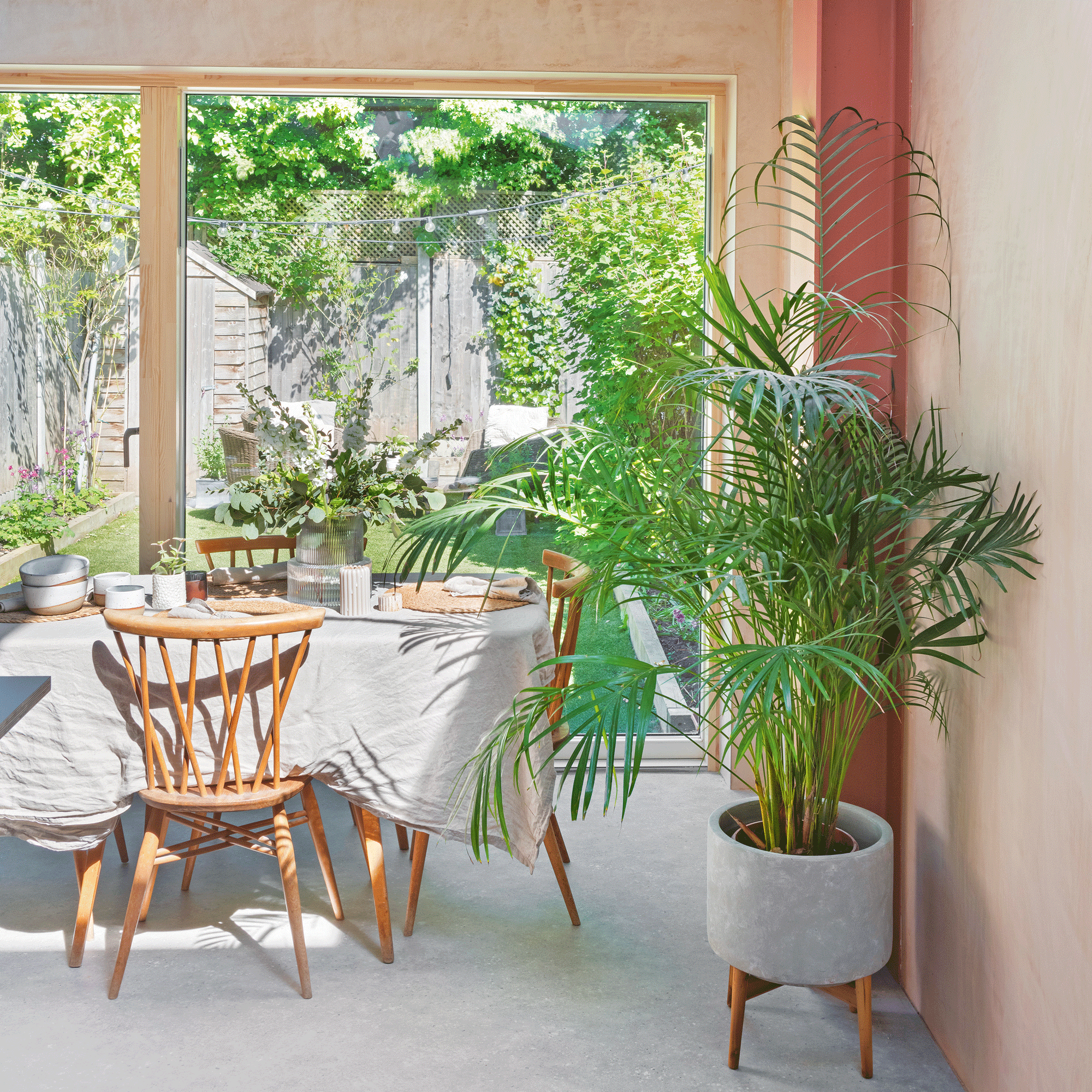 A kitchen extension with a dining table with patio doors out to a well kept garden
