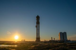 the sun sets behind a giant rocket