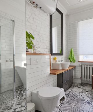A small bathroom with tiled floors and a shower and toilet