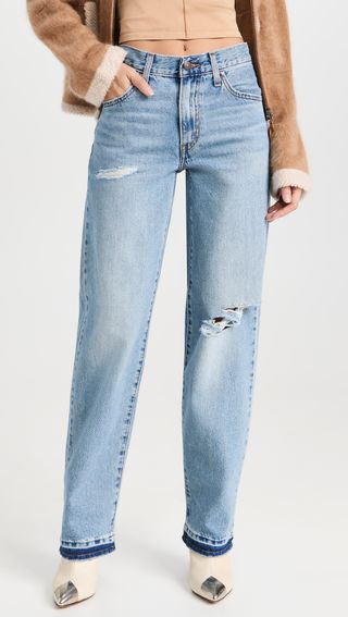 a model wears light-wash baggy jeans with rips