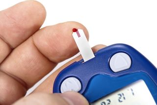 A person checks their blood sugar levels with a blood glucose meter.