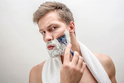 Man shaving face.