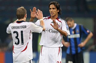 Bayern Munich's forward Roque Santa Cruz (R) greets his teammate midfielder Bastian Schweinsteiger at the end of their Champions League Group B football match against Inter Milan at San Siro stadium in Milan, 27 September 2006. On the back Inter Milan's defender Marco Materazzi reacts at the final result. Bayern Munich won 2-0.