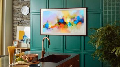 Samsung the Frame 2021, one of the best 40 inch TV options on our list, in a modern kitchen on a green wall