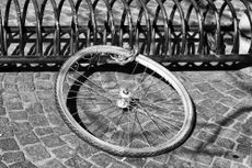 The image of just wheel locked to a bike stand shows the importance of having the best bicycle insurance 