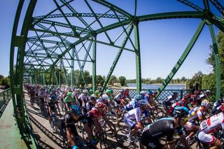 The peloton crosses the Sacramento River after the start