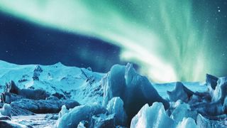 blue northern lights above glacier