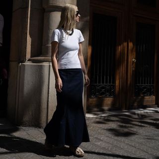 @lindatol_ wearing white t-shirt and black skirt