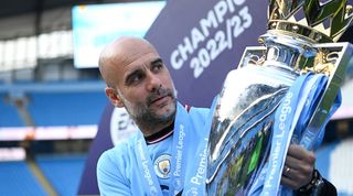 Manchester City manager Pep Guardiola holds aloft the Premier League trophy at the Etihad in May 2023.