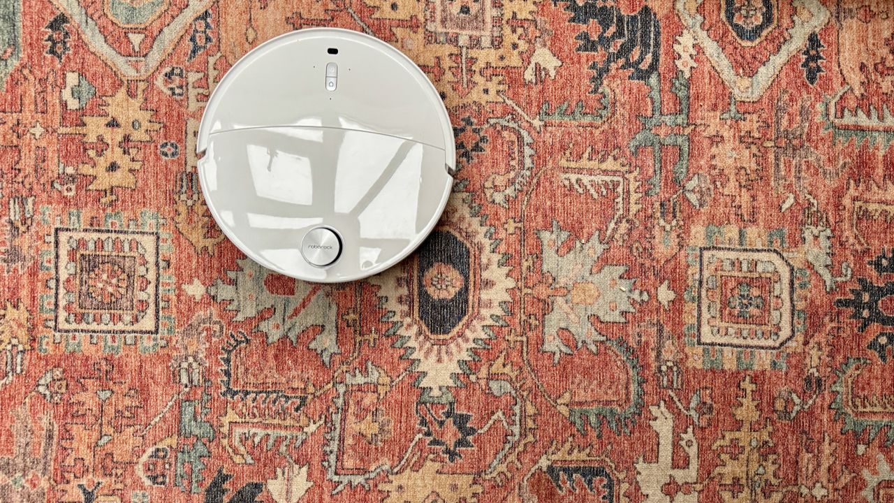 Roborock Qrevo Curv 2 Pro on a patterned carpet rug, with no oats or crumbs remaining after the vacuuming test