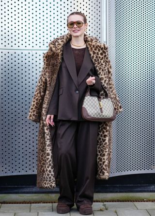 A woman wearing a suit and leopard print coat