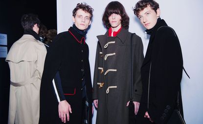 Three models stood next to each other in Burberry coats