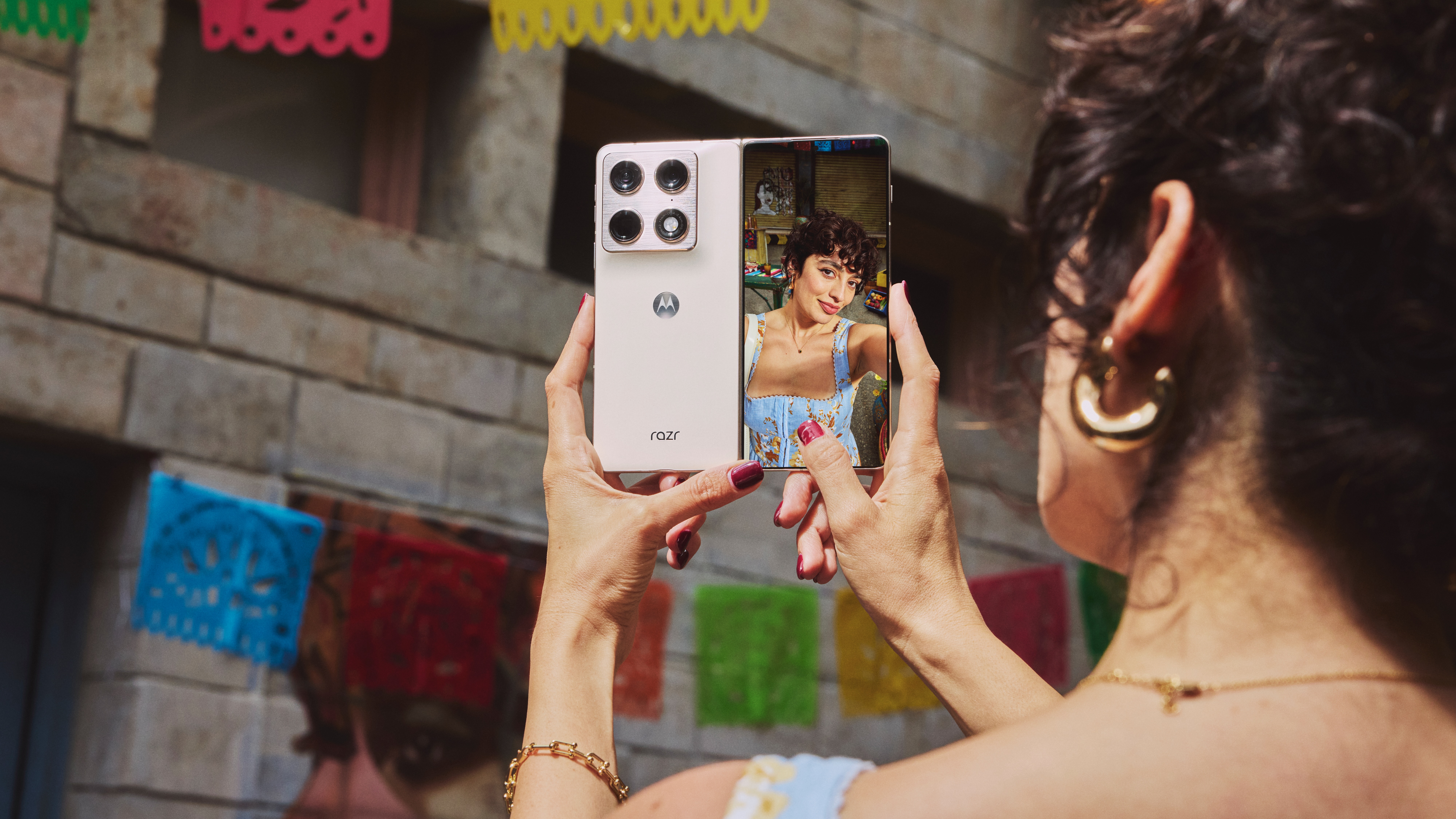 A woman taking a selfie with the Motorla Razr Fold outer camera