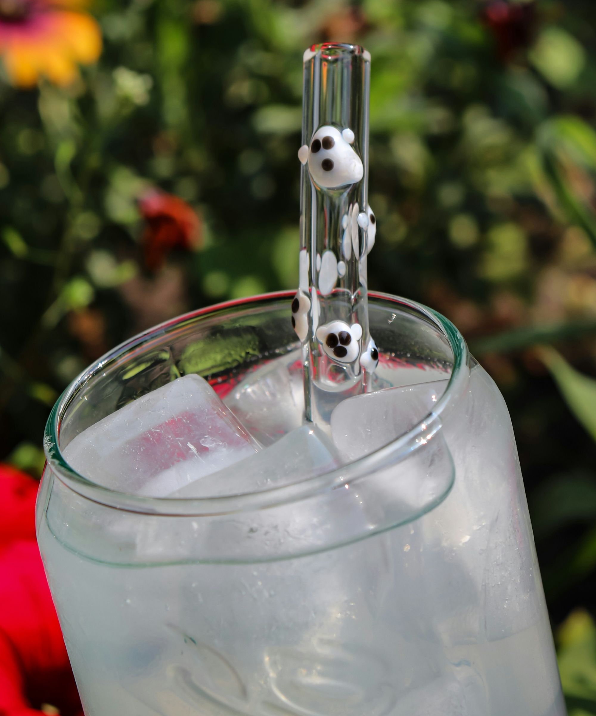 Clear water glass with a glass straw decorated with ghost designs