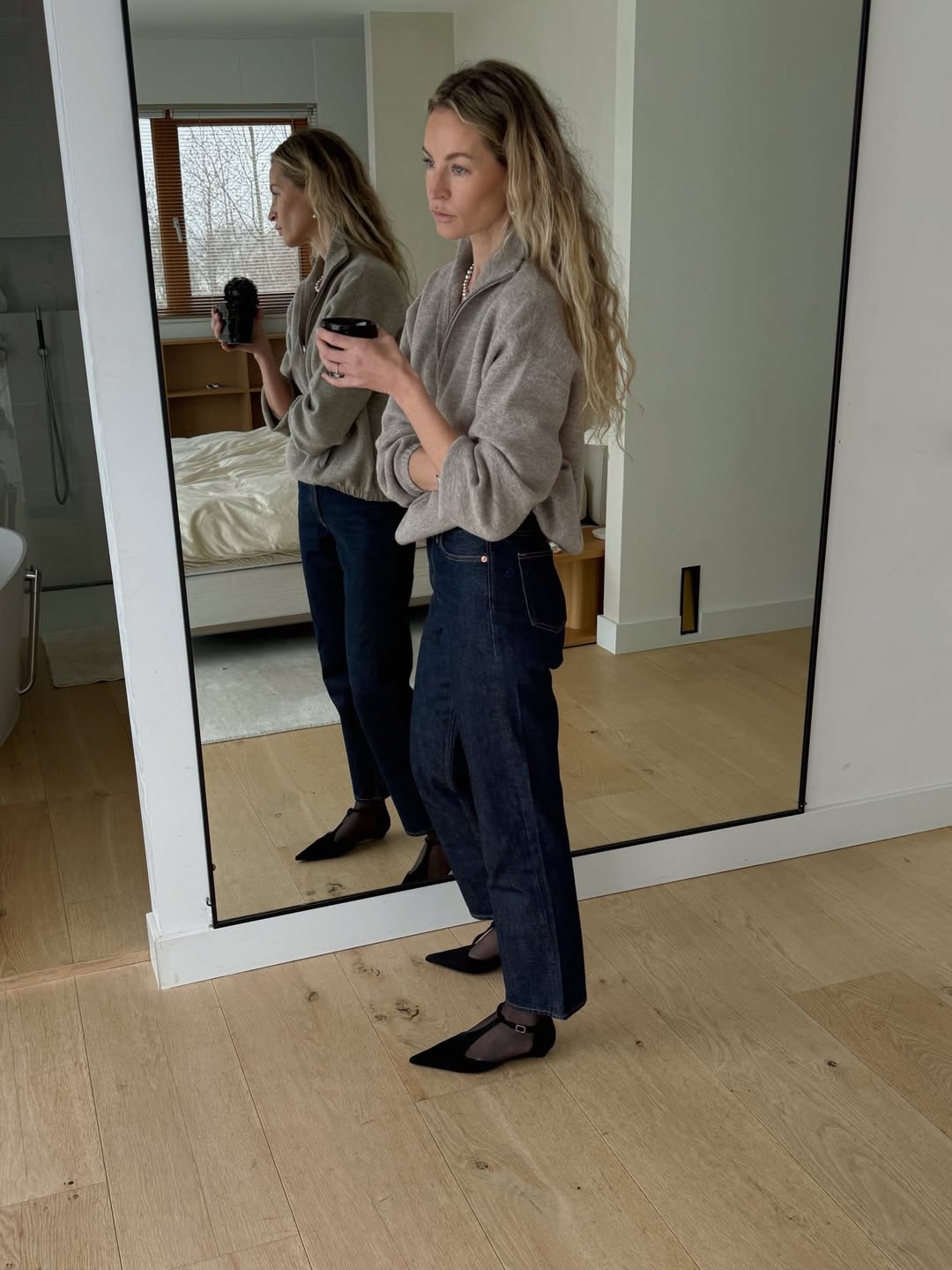 Influencer Anouk Yve wearing dark-wash jeans and t-bar flats.