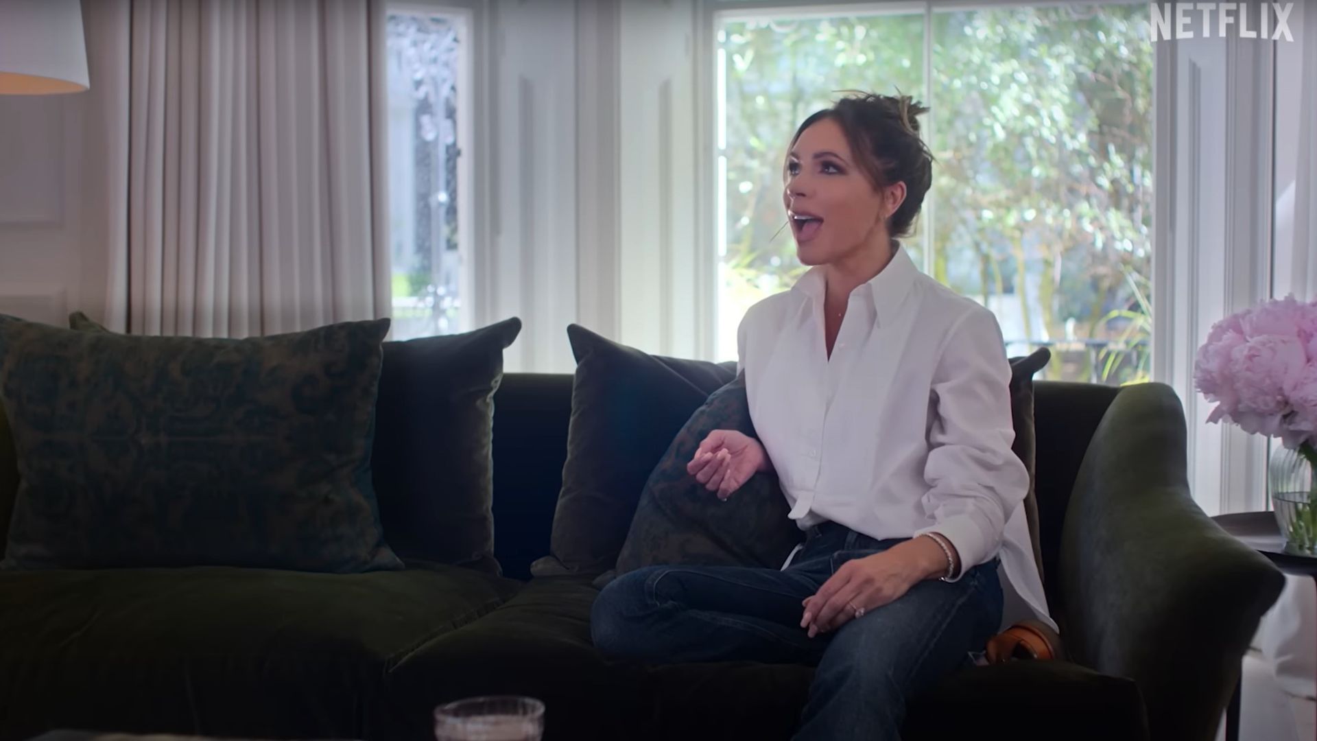 Victoria Beckham green velvet sofa - YouTube screenshot of the Netflix Beckham documentary showing Victoria sitting on green couch being interviewed
