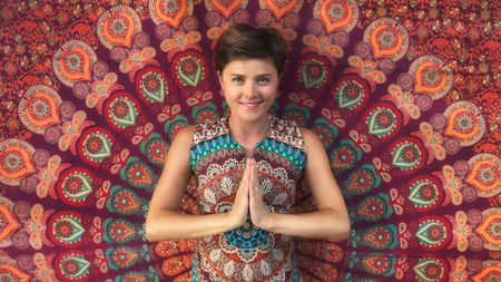 A woman presses her palms together in the namaste yoga pose.