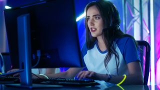 female PC gamer playing on a desktop