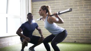 Woman squatting with barbell on back