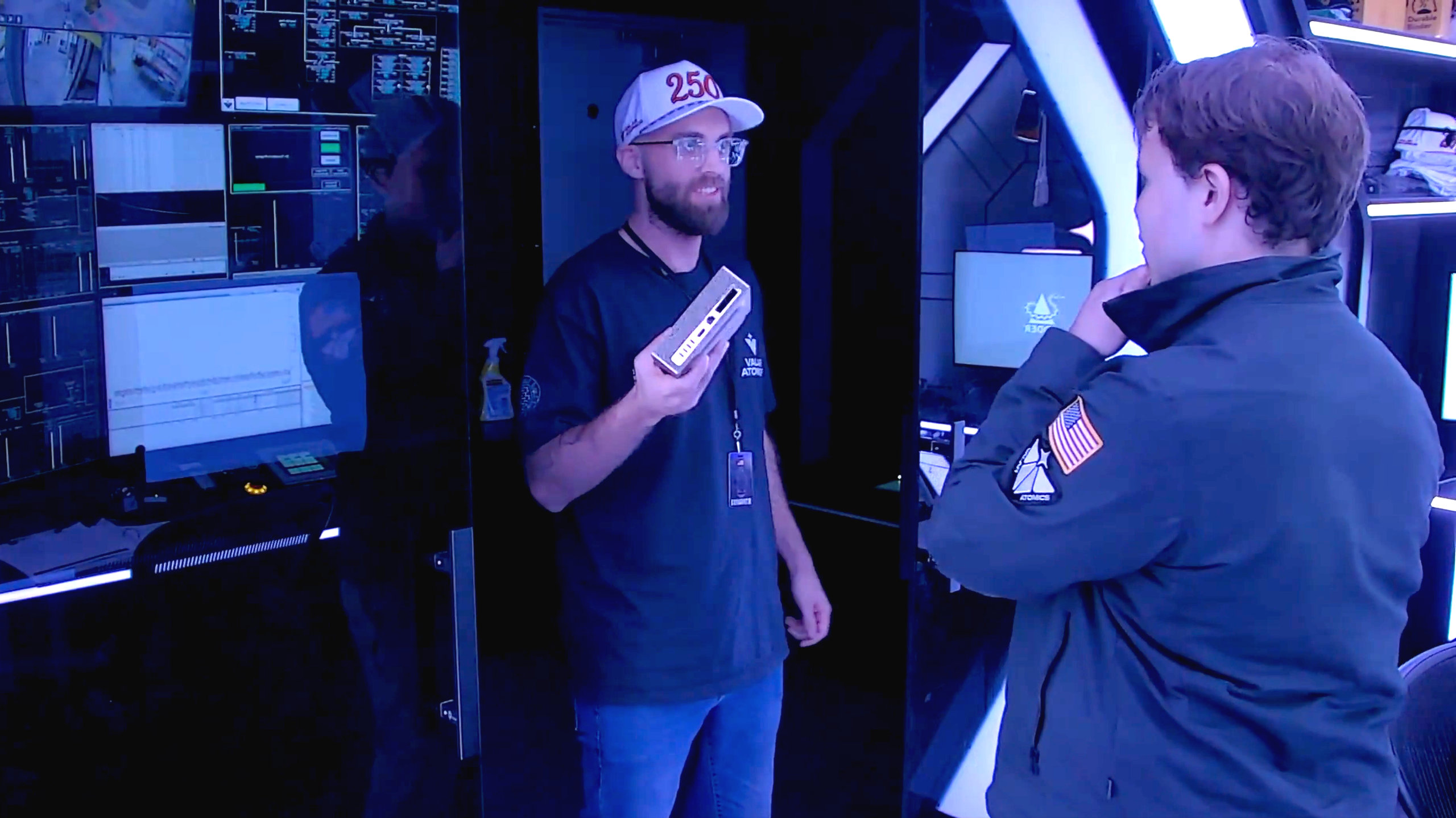 A screenshot of a Valar Atomics promotional video, showing an employee holding an Nvidia DGX Spark, ready to be powered by a nuclear microreactor.
