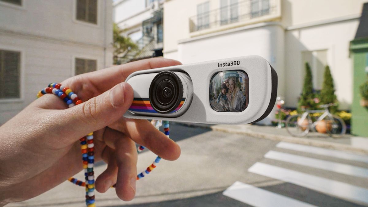 Insta360 Go 3S Retro edition, with the thumb-szied action camera slotted into the Retro Bundle's viewfinder case, held by a user