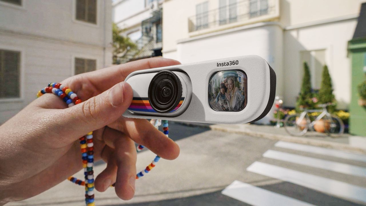 Insta360 Go 3S Retro edition, with the thumb-szied action camera slotted into the Retro Bundle's viewfinder case, held by a user